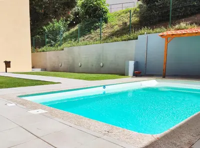 a swimming pool with blue water in a yard at Cozy Loft w Poll Near Porto Cellars in Vila Nova de Gaia