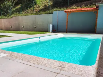 a swimming pool with blue water in a yard at Cozy Loft w Poll Near Porto Cellars in Vila Nova de Gaia