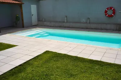 a swimming pool with blue water in a yard at Cozy Loft w Poll Near Porto Cellars in Vila Nova de Gaia