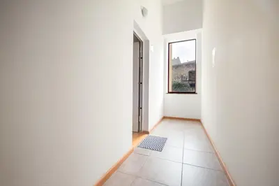 an empty hallway with a window and a tile floor at Cozy Loft w Poll Near Porto Cellars in Vila Nova de Gaia
