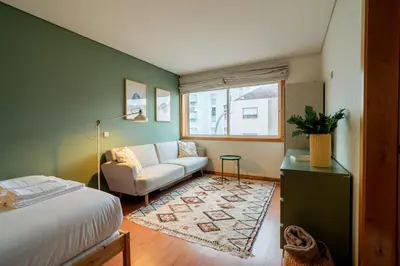 a bedroom with a bed and a couch and a window at Green Studio near Metro, Cedofeita, Porto in Porto