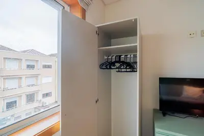 a living room with a tv and a window at Green Studio near Metro, Cedofeita, Porto in Porto