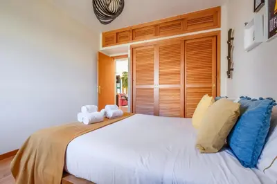 a bedroom with a large white bed with towels on it at 2 Bdr Guadiana House Garden Metro Station 2min in Porto