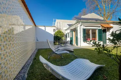 a white bench sitting in the yard of a house at 2 Bdr Guadiana House Garden Metro Station 2min in Porto