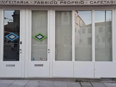 a building with four glass doors with a sign on it at Belly Angel - Porto Historic Center in Porto