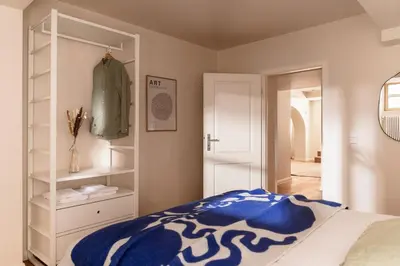 a bedroom with a blue and white bed and a closet at Apartment Nunno in Porto