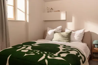 a bedroom with a green and white blanket on a bed at Apartment Nunno in Porto