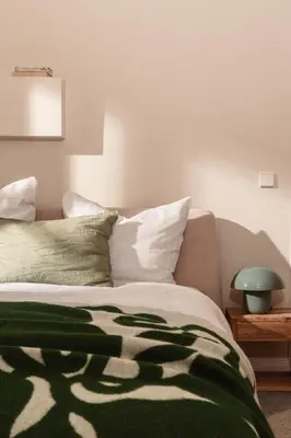 a bed with a green and white blanket on it at Apartment Nunno in Porto