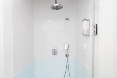 a bathroom with a shower with a light on the wall at The Cozy Loft in Porto