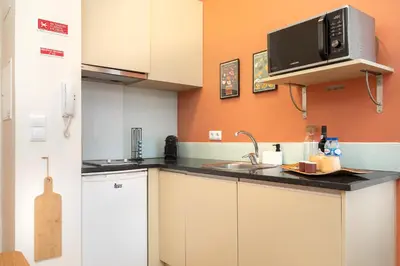 a kitchen with a sink and a microwave at The Cozy Loft in Porto