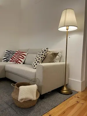 a living room with a couch and a lamp at Quiet, bright apt near Bolhão in Porto