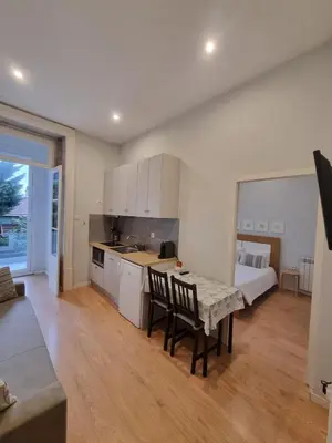 a kitchen and living room with a table and a bed at Studio in a typical Porto house in Porto