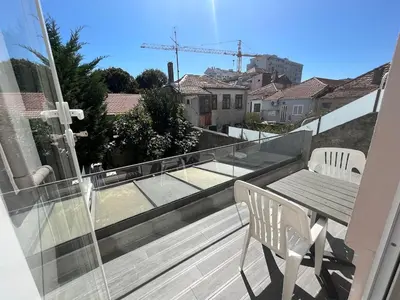 a balcony with a table and chairs on a roof at Studio in a typical Porto house in Porto
