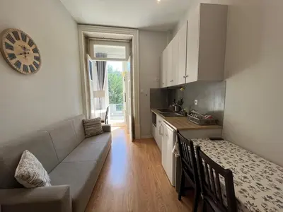 a kitchen with a couch and a table and a clock at Studio in a typical Porto house in Porto