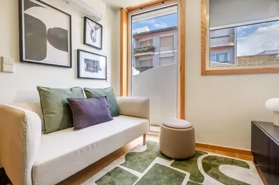 a living room with a couch and a window at Camoes Apartment with AC near Metro in Porto