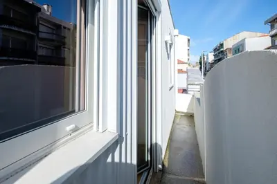 a window on a building with a view of a street at Camoes Apartment with AC near Metro in Porto