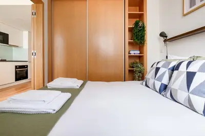 a bedroom with a bed with towels on it at Camoes Apartment with AC near Metro in Porto