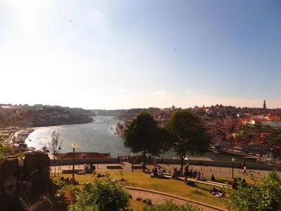 a view of a river with people sitting on benches at House T3 in Vila Nova de Gaia