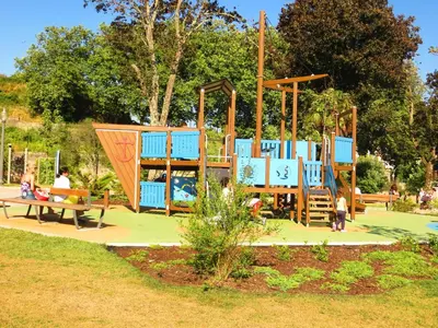 a playground in a park with people sitting on a bench at House T3 in Vila Nova de Gaia