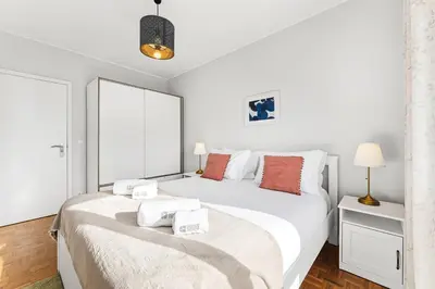 a white bedroom with two beds and a lamp at GuestReady - Cosy Porto retreat in Porto