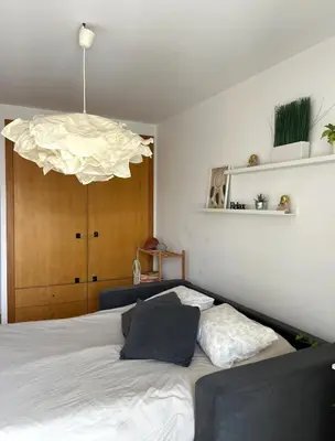 a bedroom with a white bed and a large chandelier at Quarto grande no centro do Porto in Porto