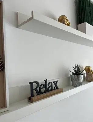 a shelf with a relax sign in a living room at Quarto grande no centro do Porto in Porto