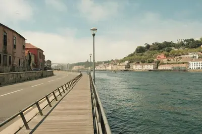 a wooden bridge over a river next to a street at Douro Prestige Studio in Vila Nova de Gaia