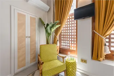 a yellow chair in a room with a window at Victoria Project - Houses - Private Parking in Porto