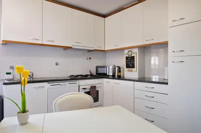 a kitchen with white cabinets and a table and chairs at Wander Unwind - Wine Cellars in Vila Nova de Gaia