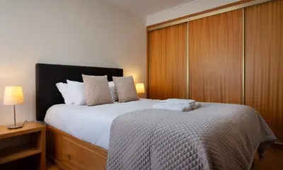 a bedroom with a large bed and a wooden cabinet at Wander Unwind - Wine Cellars in Vila Nova de Gaia
