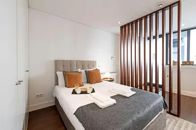 a bedroom with a large bed with towels on it at Carlos Alberto Apartment in Porto