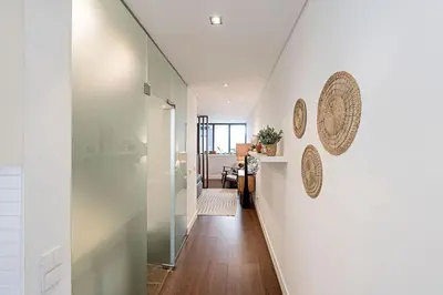 a hallway with white walls and a glass door at Carlos Alberto Apartment in Porto