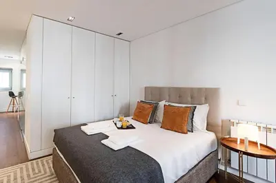 a bedroom with a large bed with white walls at Carlos Alberto Apartment in Porto