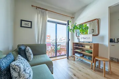 a tv stand in a living room with a plant at Charming retreat near Boavista with elevator in Porto