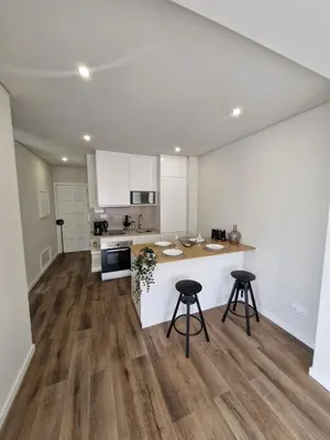 a kitchen with a counter and two stools at Essence Santa Catarina Flat in Porto