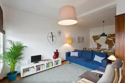 a living room with a blue couch and a tv at PinPorto City Center I in Porto