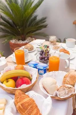 a table full of breakfast foods and orange juice at Lusitana Hotel in Porto