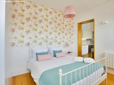 a bedroom with a white bed with pink and blue pillows at Charming Apartments in Historic Centre - Inside Porto Apartments 