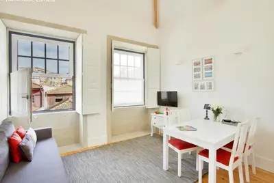 a living room with a table and a couch and a window at Charming Apartments in Historic Centre - Inside Porto Apartments 