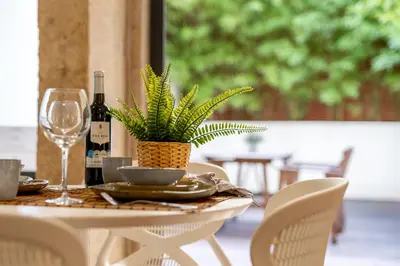 a table with a bottle of wine and a plant on it at Merc Porto Clérigo's Place in Porto