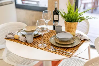a table with glasses and plates and a bottle of wine at Merc Porto Clérigo's Place in Porto