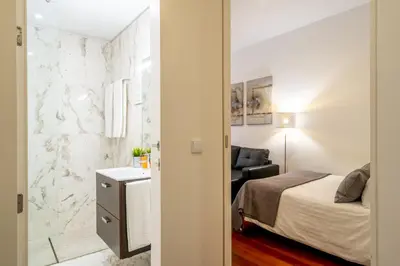 a bedroom with a bed and a chair in a room at Merc Porto Clérigo's Place in Porto