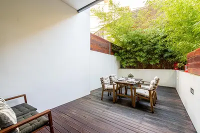 a patio with a table and chairs on a deck at Merc Porto Clérigo's Place in Porto