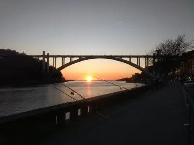 a bridge over a river with the sun setting at Merc Porto Clérigo's Place in Porto