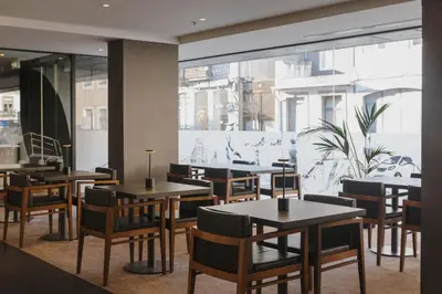 a restaurant with tables and chairs and a large window at Timbre Heroismo in Porto