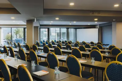 a conference room with tables and chairs and a whiteboard at Timbre Heroismo in Porto