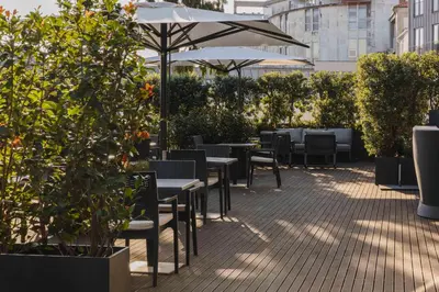 a patio with tables and chairs and an umbrella at Timbre Heroismo in Porto