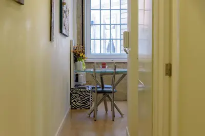 a table with a chair in a room with a window at Cativo Flat in Porto