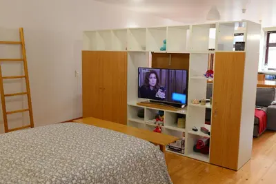 a bedroom with a bed and a tv on a shelf at Loft Taipas in Porto