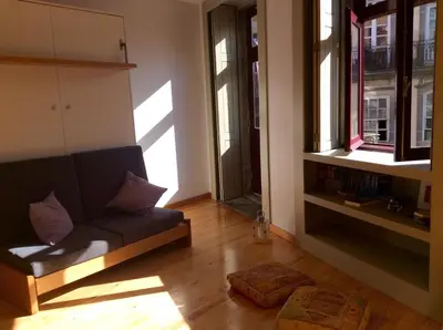 a living room with a couch and some windows at Loft Taipas in Porto
